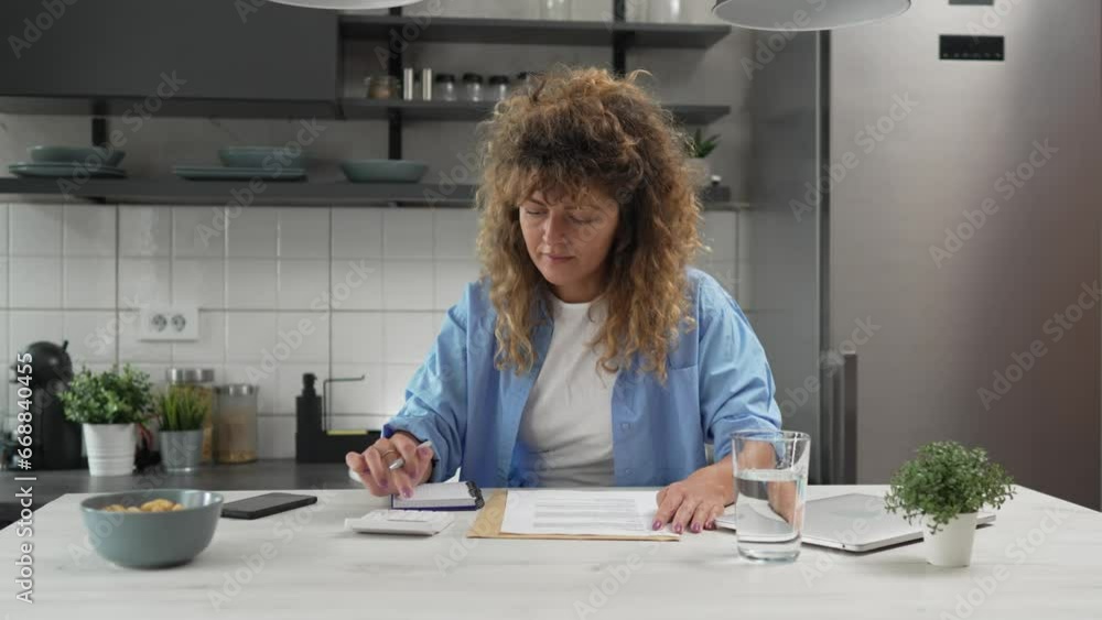 Caucasian woman at home use calculator to calculate expenses and taxes Caucasian woman at home use calculator to calculate expenses and taxes