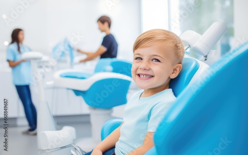 A happy child sitting in the dental chair at a dentist photo
