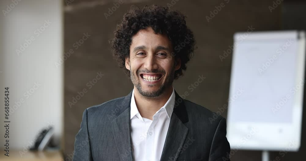 Head shot of smiling handsome Moroccan middle-aged business man in elegant formal suit posing for camera at workplace in modern office. CEO, executive manager, professional occupation person portrait Head shot of smiling handsome Moroccan middle-aged business man in elegant formal suit posing for camera at workplace in modern office. CEO, executive manager, professional occupation person portrait