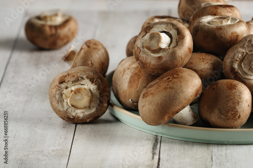Fresh organic brown champignon mushrooms on a plate. Selective focus, natural light