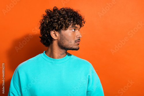 Profile photo of focused calm young person look empty space advert isolated on orange color background