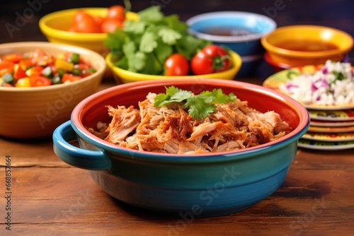 table with bbq pulled pork in a colorful ceramic bowl