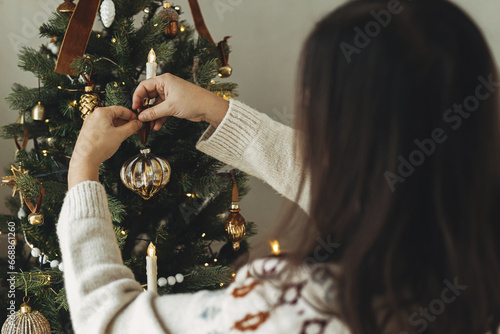 Obraz na plátne Decorating christmas tree with stylish bauble