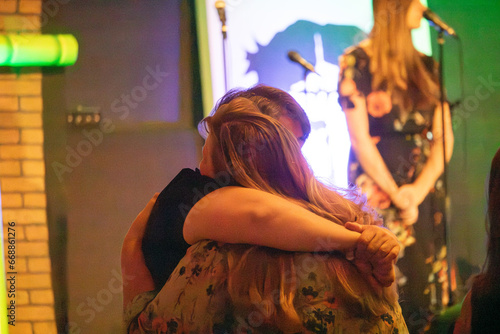 Women hugging and praying during church service invitation