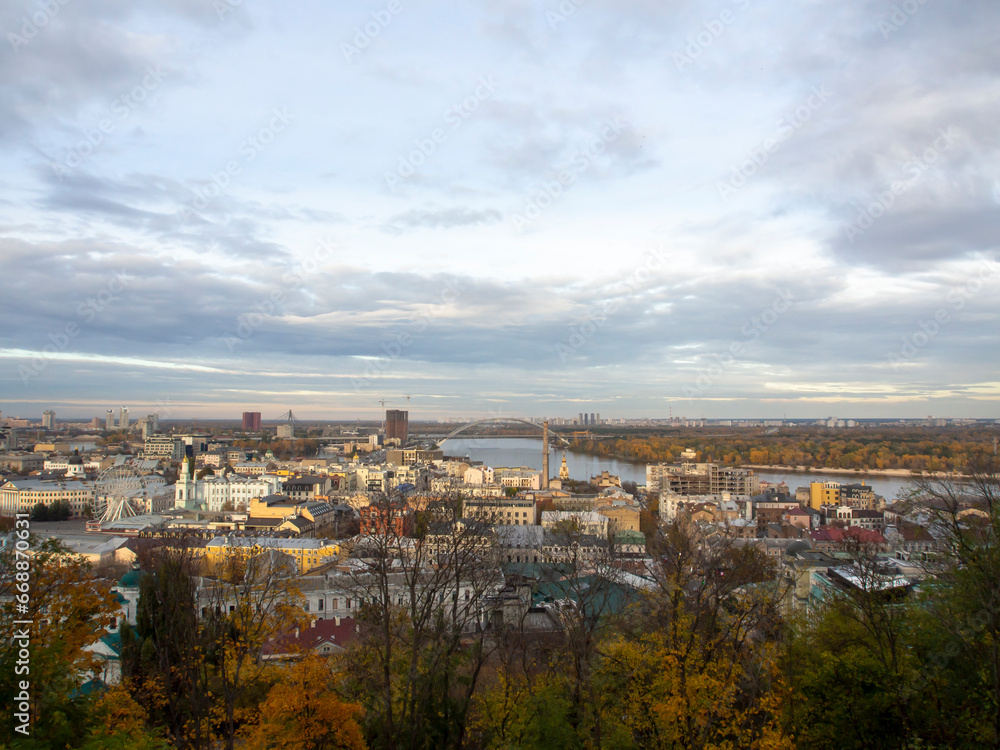View of the Dnipro River and yellow trees in the center of the city. Historical architecture and landscape, nature of Kyiv. The city center of Kyiv, Ukraine in autumn. Beautiful sky.