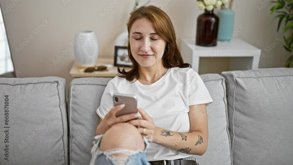 Young woman using smartphone sitting on sofa at home Young woman using smartphone sitting on sofa at home