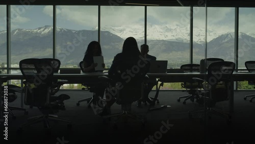 Silhouette of business people reading paperwork in conference room with scenic view / Pleasant Grove, Utah, United States photo