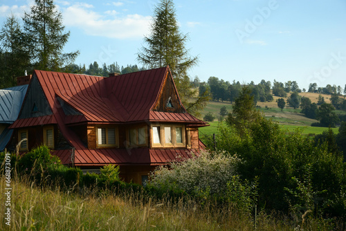 wooden old house on a hill against a background of a mountain landscape