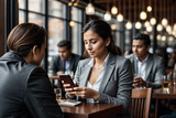 A woman sitting at a table using a cell phone at a restaurant, 