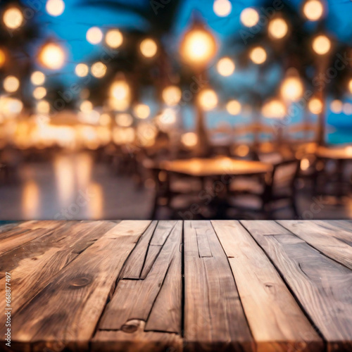Empty wooden table and abstract blurred background of cafe with bokeh light. Wooden table with blur beach cafes background and bokeh lights created. 