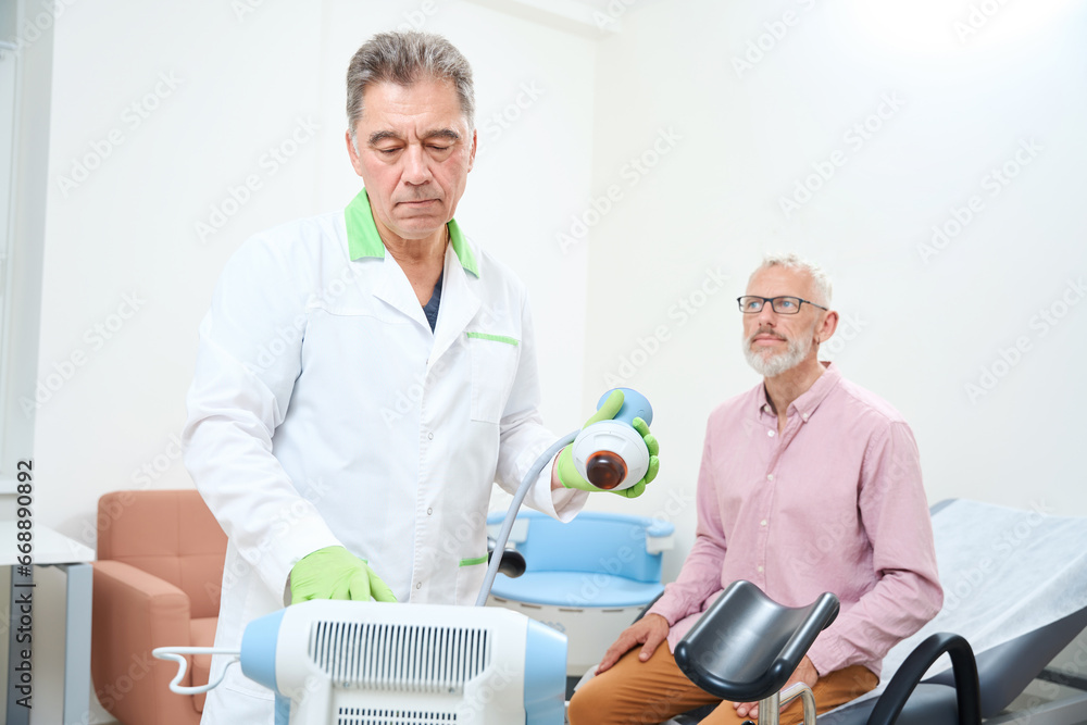Medical worker sets up a device for physiotherapy Medical worker sets up a device for physiotherapy