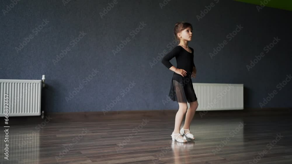 Child girl standing in black sport bodysuit in dancing studio during training posture. 4 5 years old preschool age. Healthy physical development Child girl standing in black sport bodysuit in dancing studio during training posture. 4 5 years old preschool age. Healthy physical development