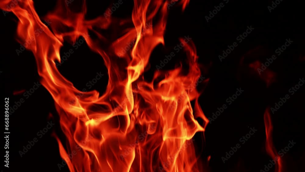 Tongues of flame burning at night. Isolated fire swaying in the wind in darkness. Tongues of flame burning at night. Isolated fire swaying in the wind in darkness.