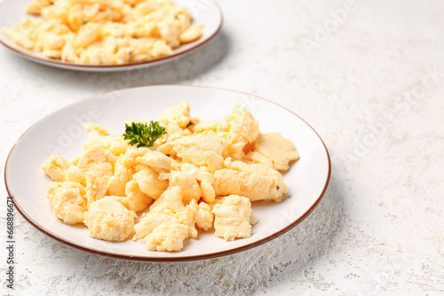 Plates of scrambled eggs on light textured background