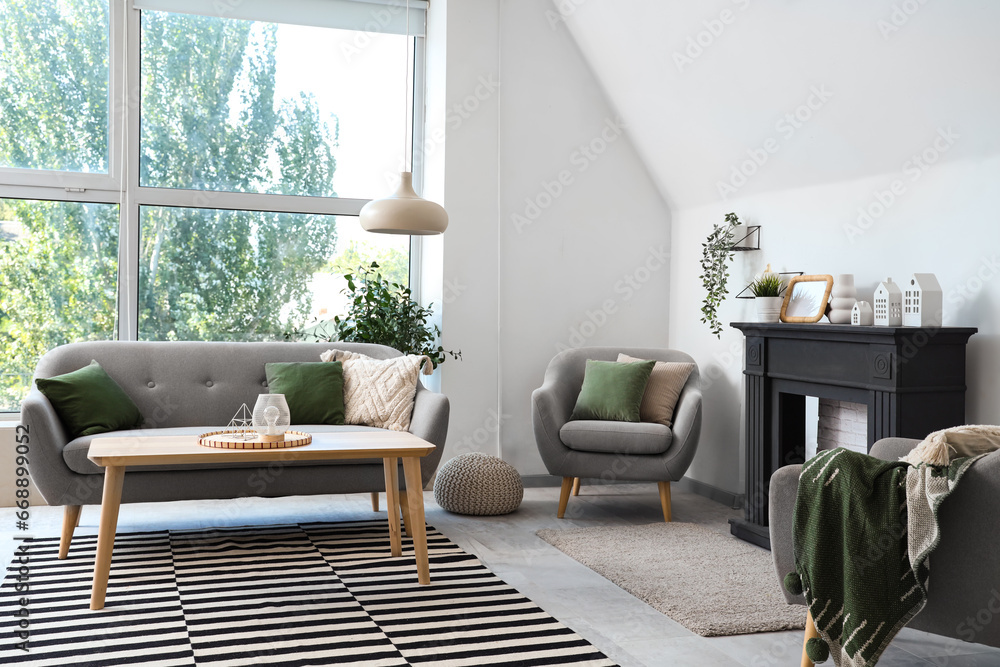 Obraz na płótnie Interior of light living room with decorative fireplace, sofa and houseplants w salonie