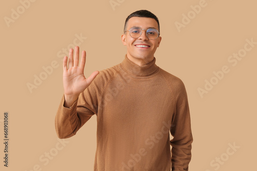 Handsome young man waving h...