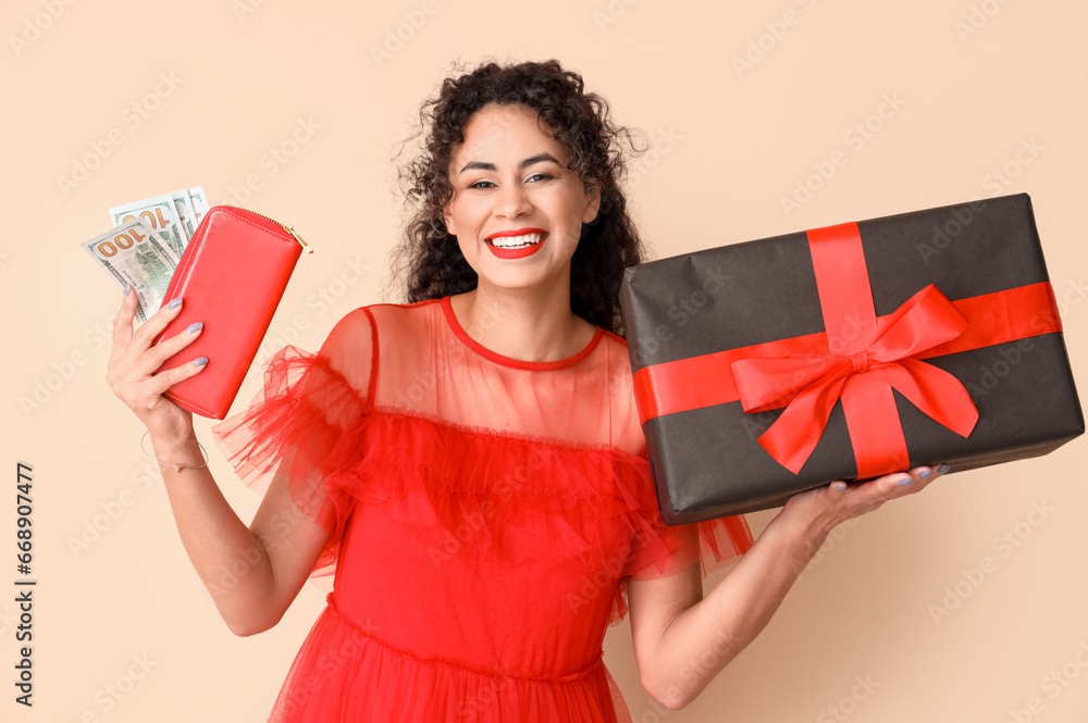 Beautiful African-American woman with gift box, wallet and money on beige background. Black Friday sale Beautiful African-American woman with gift box, wallet and money on beige background. Black Friday sale