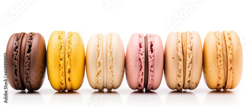 Five French macarons with various aromas isolated on white in pastel colors orange lemon caramel vanilla and coconut photo