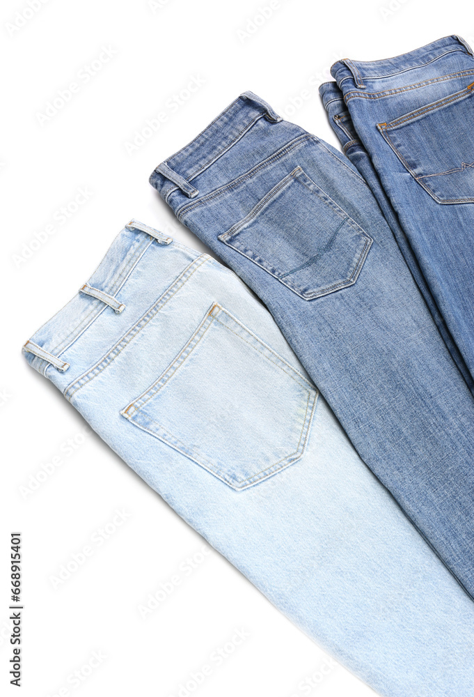 Different stylish jeans isolated on white, above view