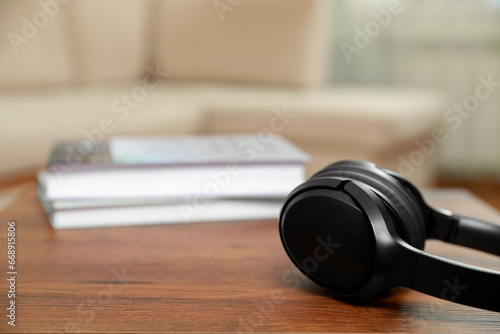 Modern wireless headphones on wooden table indoors, closeup. Space for text © New Africa