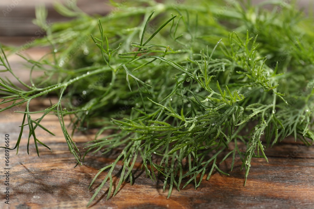 Fresh green dill with water drops on wooden table, closeup Fresh green dill with water drops on wooden table, closeup