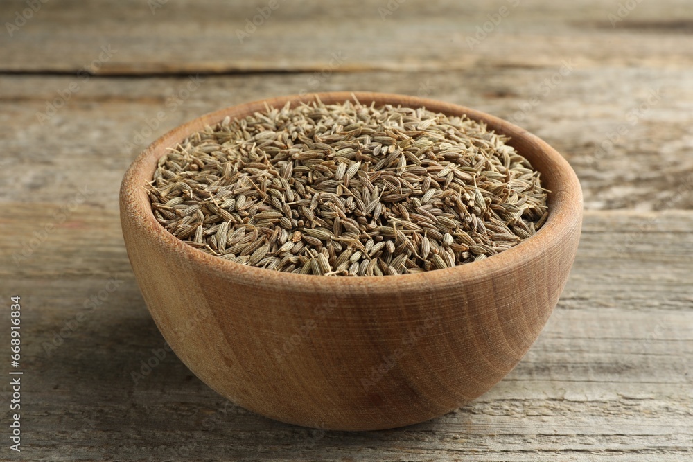 Bowl of caraway seeds on wooden table, closeup Bowl of caraway seeds on wooden table, closeup