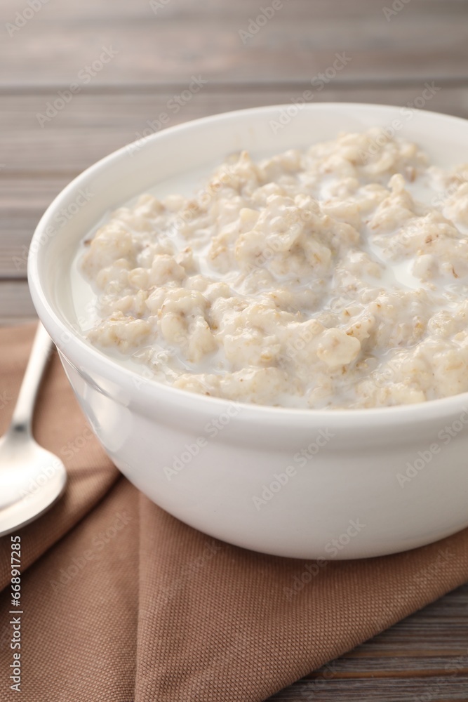 Tasty boiled oatmeal in bowl on table, closeup Tasty boiled oatmeal in bowl on table, closeup