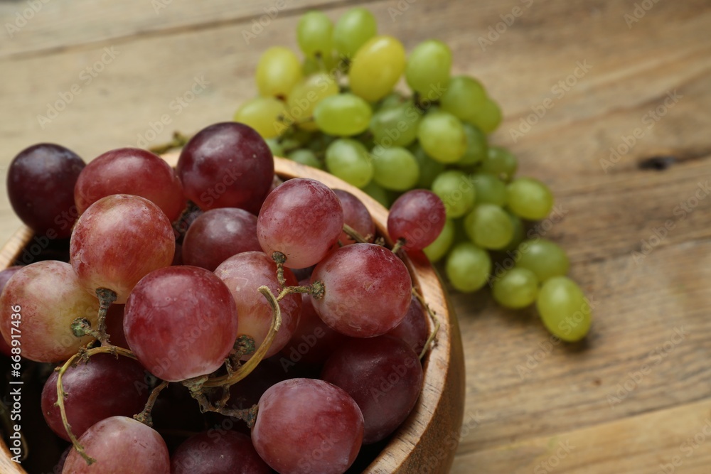 Different fresh ripe grapes on wooden table, closeup. Space for text Different fresh ripe grapes on wooden table, closeup. Space for text