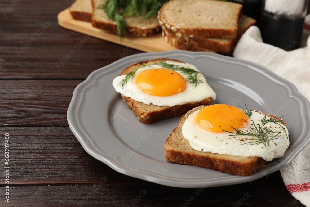 Plate with tasty fried eggs, slices of bread and dill on dark wooden table. Space for text Plate with tasty fried eggs, slices of bread and dill on dark wooden table. Space for text
