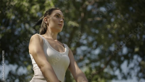 young Spanish woman exercising her body with elastic bands in a park in her city