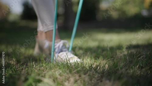 young Spanish woman exercising her body with elastic bands in a park in her city