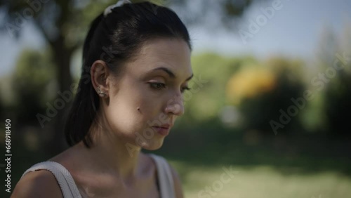 portrait of a woman looking around and breathing consciously in an open-air park