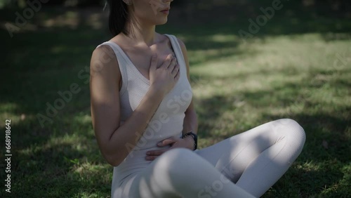 young woman practising breathing exercises in a park