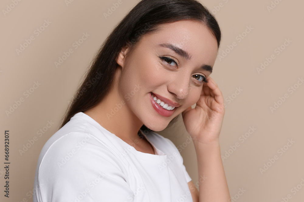 Portrait of beautiful young woman with elegant makeup on dark beige background Portrait of beautiful young woman with elegant makeup on dark beige background