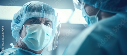 Surgeons in protective attire seen from below during surgery