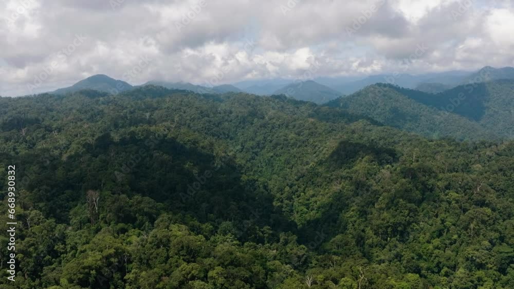 Aerial view of mountains covered rainforest, trees and blue sky with clouds. Sumatra, Indonesia. Aerial view of mountains covered rainforest, trees and blue sky with clouds. Sumatra, Indonesia.