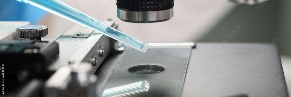 Scientist examines blue reagent under electronic microscope Scientist examines blue reagent under electronic microscope