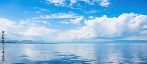 Summer mornings over the sea reveal a backdrop of clear blue sky with a white cloud © AkuAku