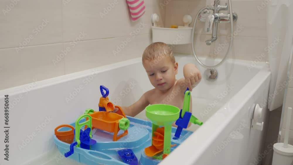 toddler child little boy playing with bath toys taking a bath in the bathroom toddler child little boy playing with bath toys taking a bath in the bathroom