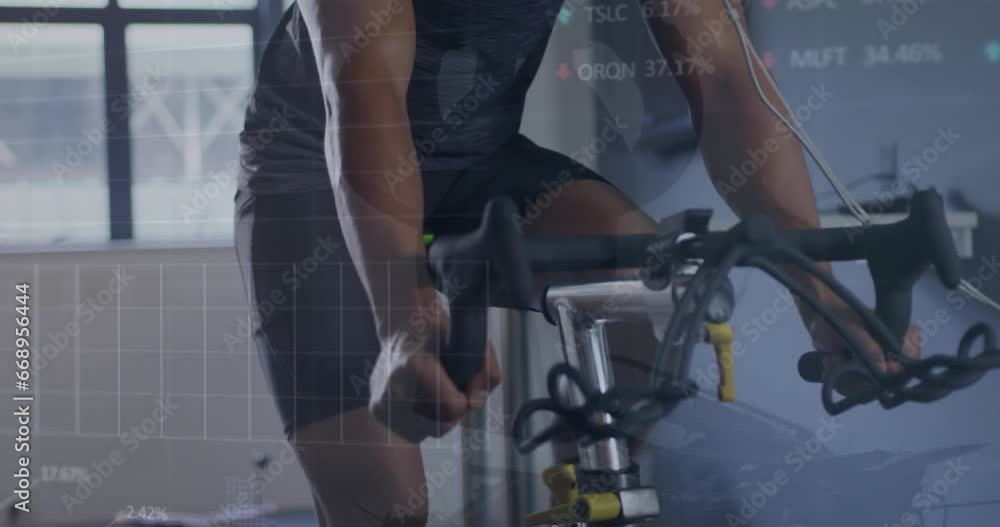 Animation of stock market data processing over biracial fit man training on exercise bike at the gym Animation of stock market data processing over biracial fit man training on exercise bike at the gym