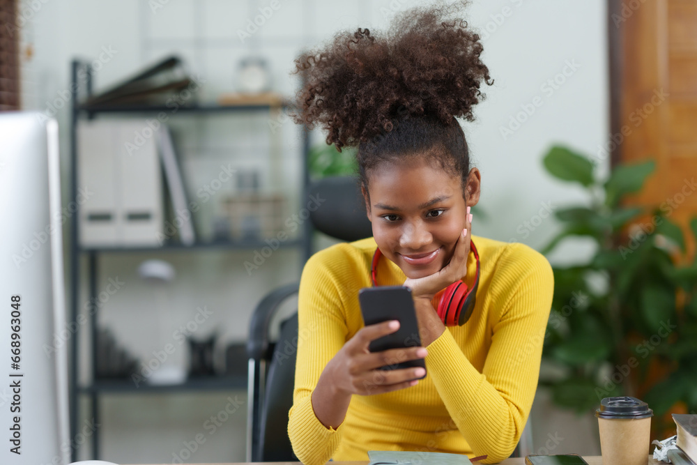 Happy african american young woman using smartphone at home. Happy african american young woman using smartphone at home.