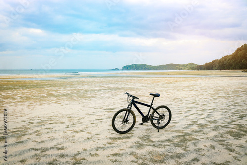 Mountain bike on a sandy beach against the backdrop of the sea. Travel, action, vacation, healthy lifestyle concept.