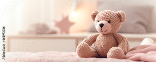 A cute knitted bear on a bed in bedroom photo