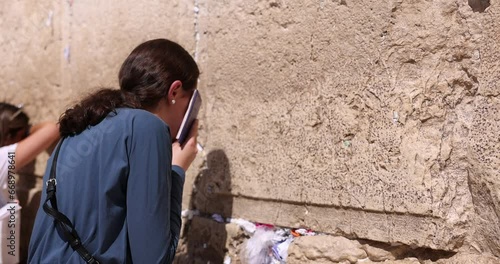 Orthodox Jew facing the Western wall praying. Jewish Girl praying. Other religious women in background pray to the Kotel. Wailing wall Jerusalem, Jerusalem, Israel. God's religion and conflict