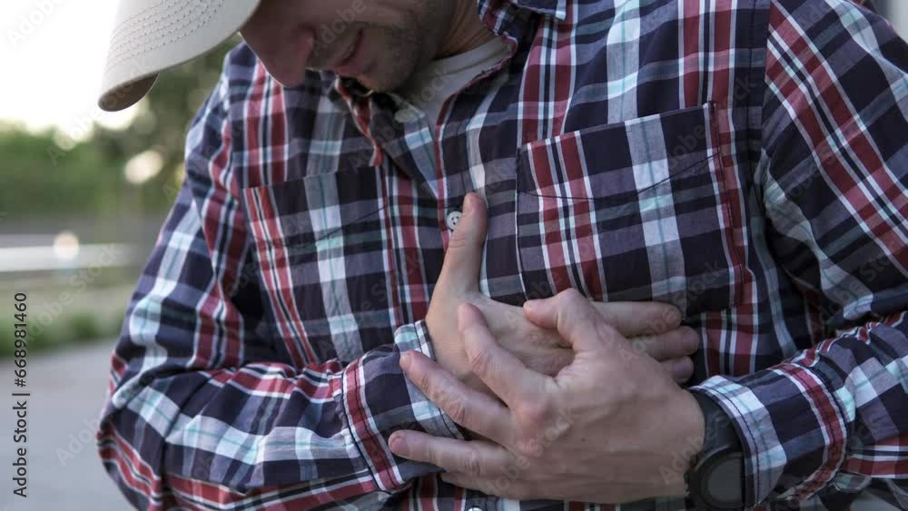 A man feels a sharp pain in his heart on his way to work. Sports and injury concept. A man feels a sharp pain in his heart on his way to work. Sports and injury concept.
