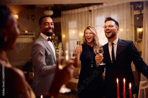 Group of happy friends have fun while celebrating Christmas and drinking champagne at home.