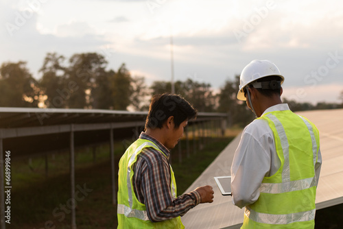 Two engineers discuss maintenance plans for solar cells. Renewable energy with solar generators. Renewable energy concepts for the future world. © Subhakitnibhat