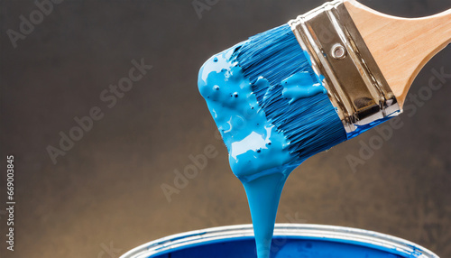 Close-up view of a blue paint container with a dripping paintbrush