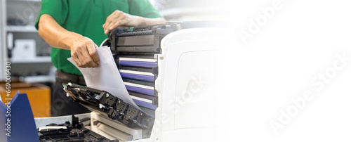 Technician hand open cover photocopier or photocopy to fix repair copier problem paper jam and replace ink cartridges for scanning fax or copy document in office workplace concept of service support.