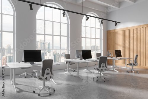 Elegant workplace interior with pc monitors on table in row, panoramic window © ImageFlow